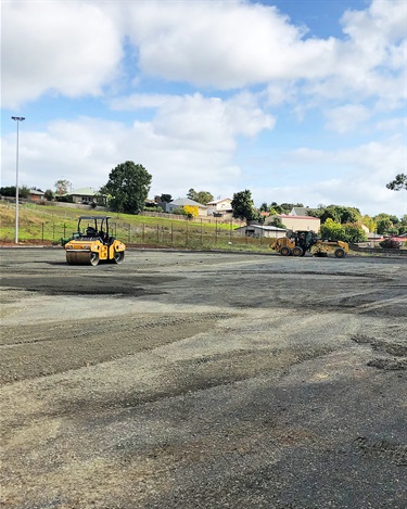 Layers of crushed rock are compacted to create a firm subsurface for the new playing field.