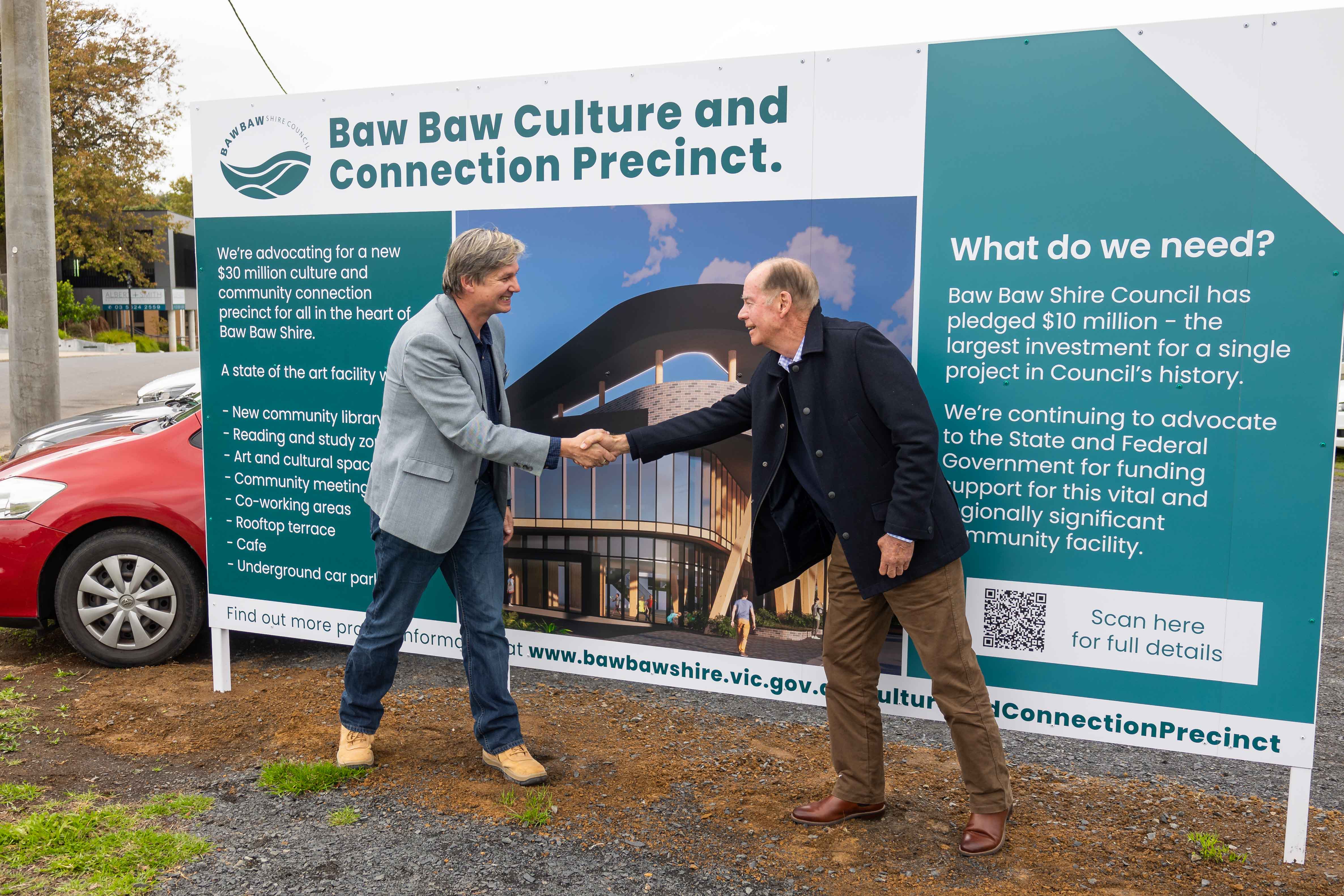 Mayor of Baw Baw Shire Cr Michael Leaney and Federal Member for Monash Russell Broadbent MP shake hands in front of the Baw Baw Culture and Connection Precinct project sign in Civic Park, Warragul.